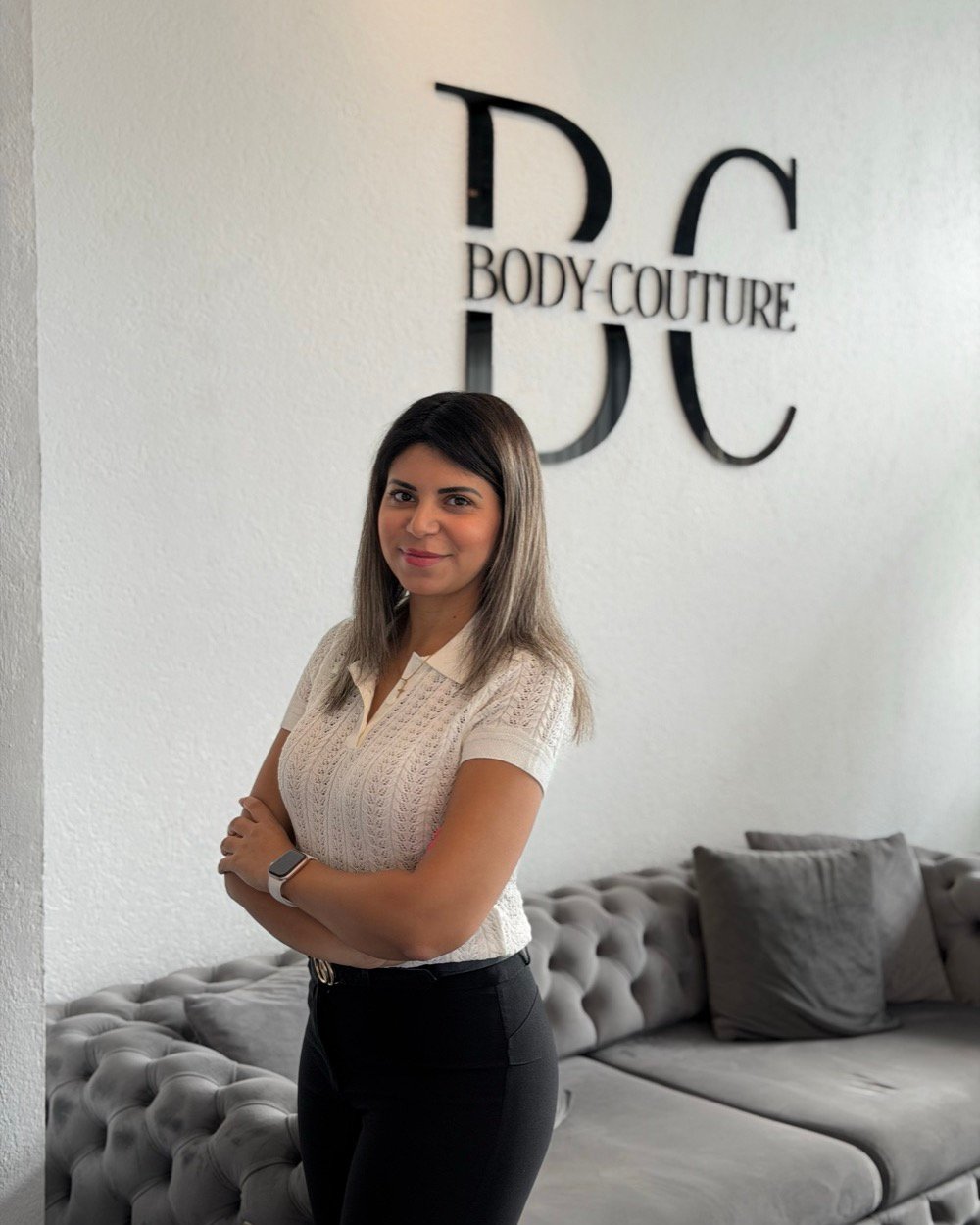 Marina, die Leiterin des Studios von Body Couture in Graz, vor dem Markenzeichen im Empfangsbereich